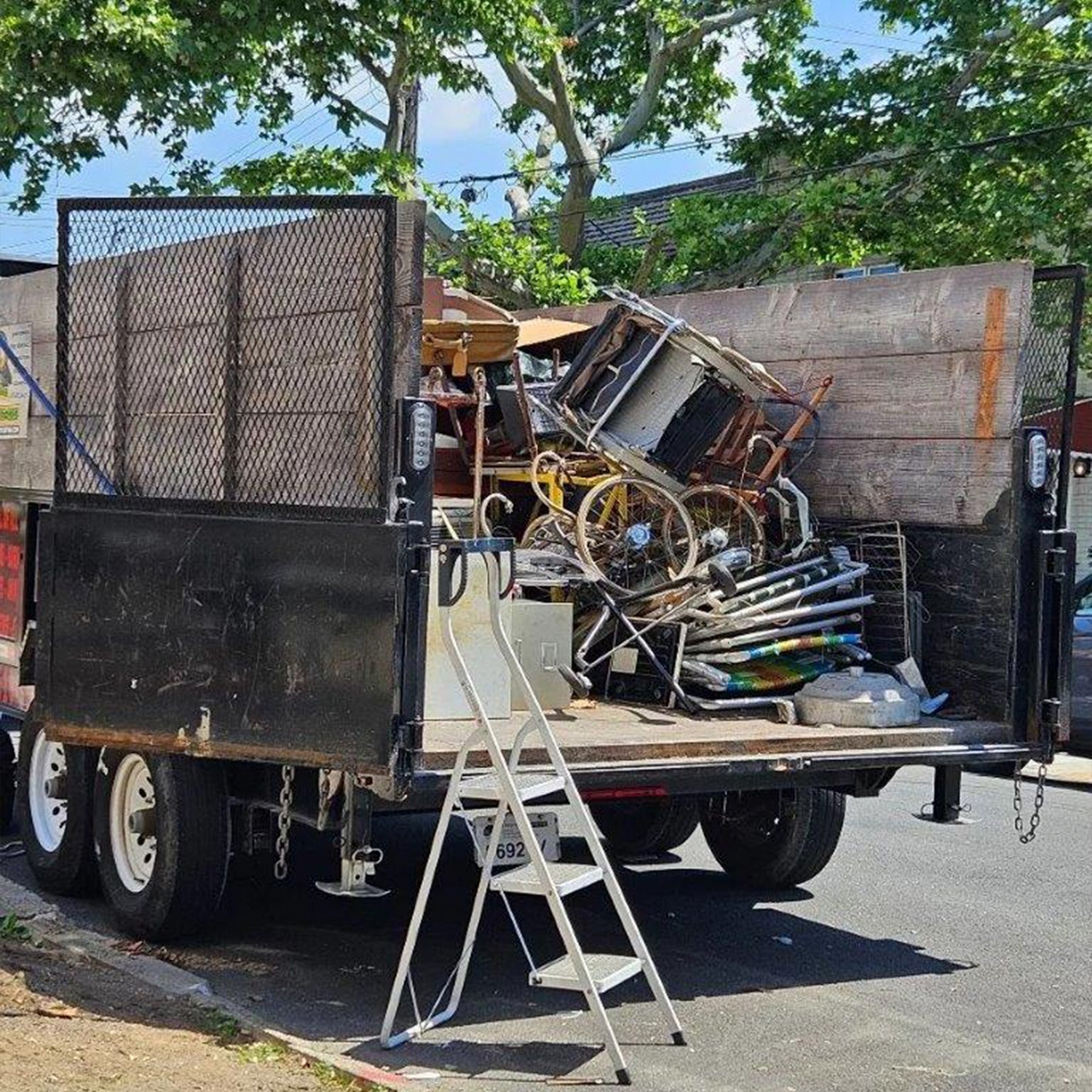 a truck with a ladder and a pile of objects in the back