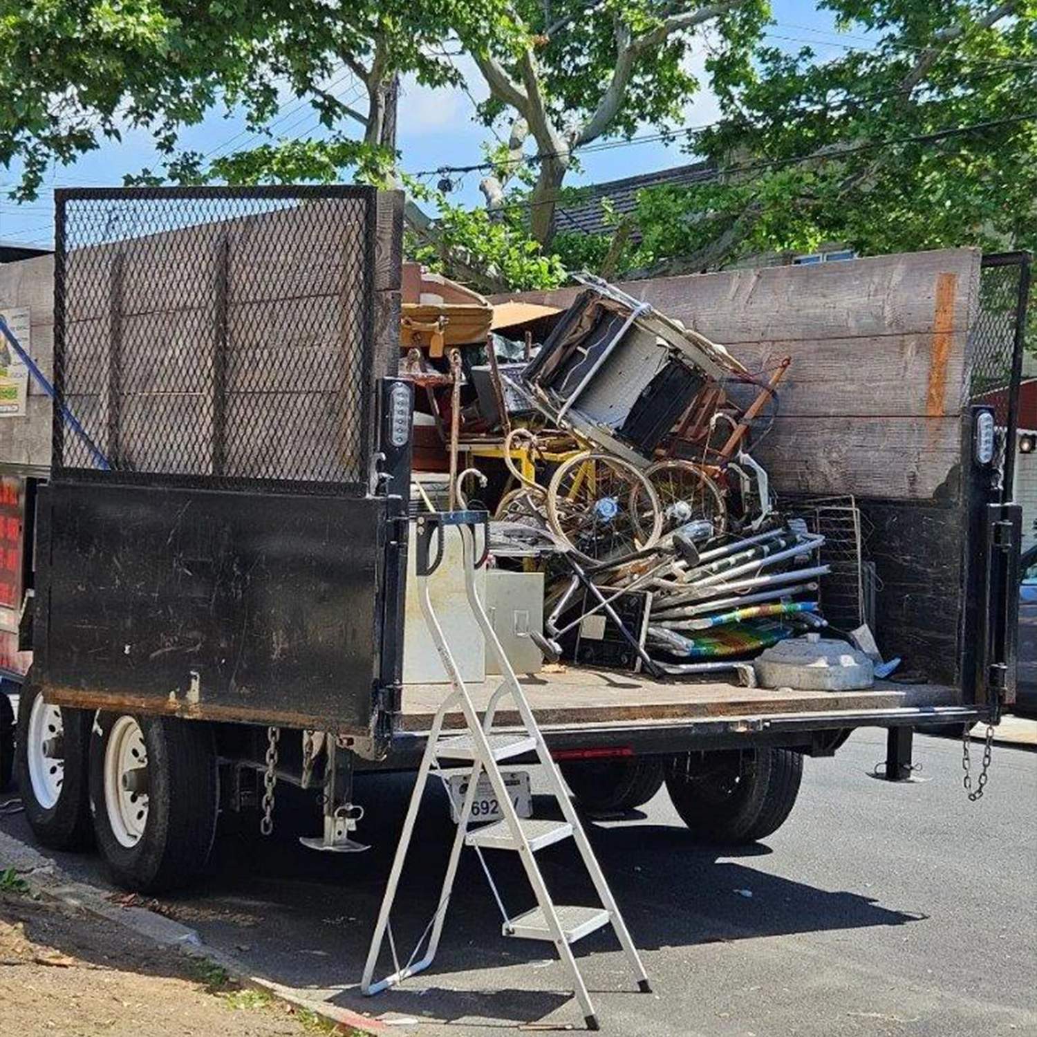 a truck with a ladder and a pile of objects in the back